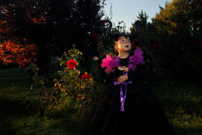 Full length of woman standing by purple flowering plants