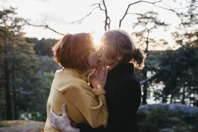 Female couple kissing at sunset