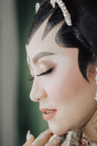 Close-up portrait of young woman with eyes closed