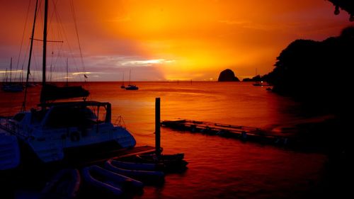 Boats sailing in sea during sunset