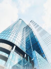 Low angle view of modern glass building against sky