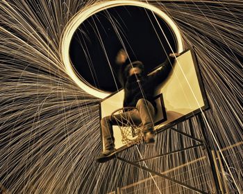 Low angle view of man spinning wire wool on basketball hoop