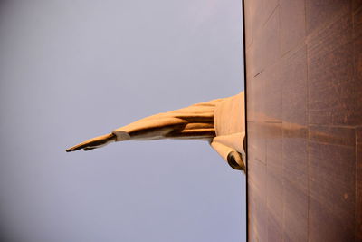 Low angle view of arm of christ the redeemer against clear sky