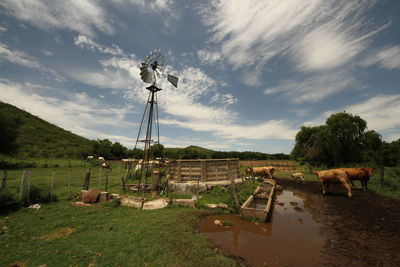 Traditional windmill on field against sky