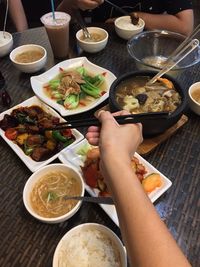 Midsection of woman eating food on table