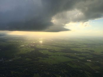 Scenic view of field against storm clouds