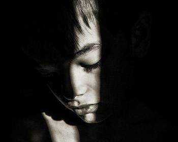 Close-up of woman over black background