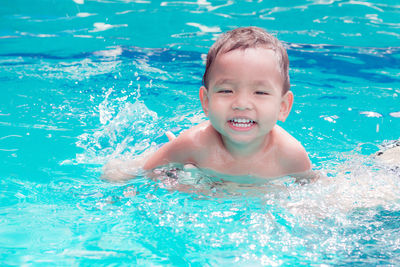 Portrait of smiling boy swimming in pool