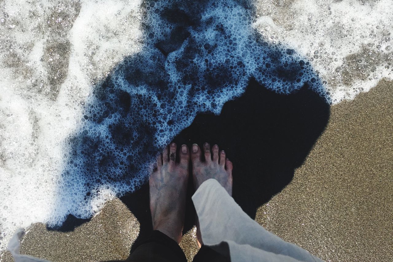 low section, standing, person, lifestyles, leisure activity, high angle view, beach, human foot, men, unrecognizable person, personal perspective, sand, day, street, outdoors, sunlight