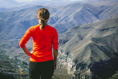 Rear view of woman standing against mountains