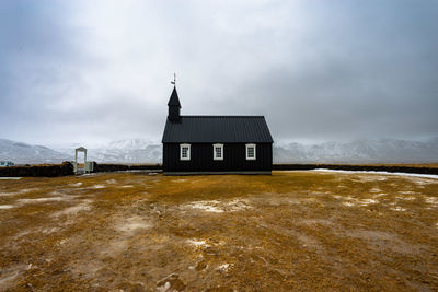 Black church of budhir with mountains coverd in snow in the background