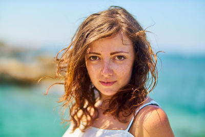 Portrait of young woman against sea
