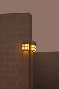 Low angle view of illuminated lamp on wall at night