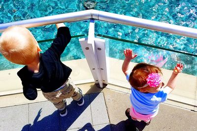 High angle view of children standing by railing