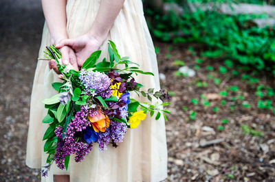 Midsection of woman holding flower bouquet