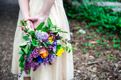 Midsection of woman holding flower bouquet