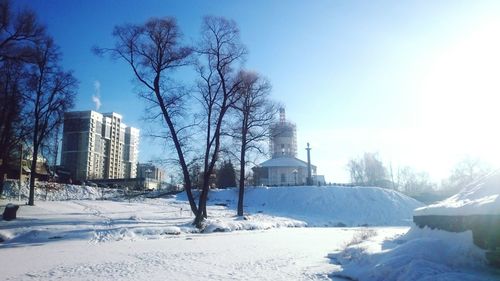 Snow covered buildings against clear sky
