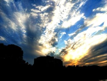 Low angle view of silhouette buildings against sky