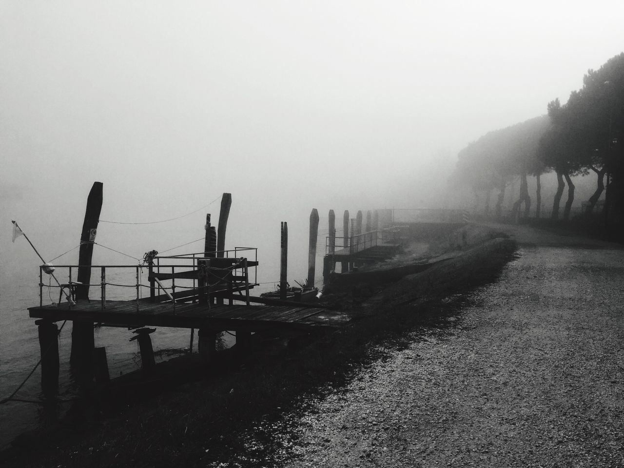 clear sky, copy space, built structure, water, foggy, architecture, sky, tranquility, nature, pier, weather, outdoors, tranquil scene, river, no people, transportation, day, sea, building exterior