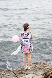 Rear view of woman standing in sea