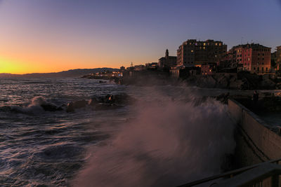 Panoramic view of sea and buildings against sky during sunset