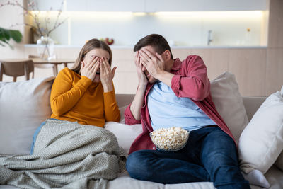 Female friends sitting on bed at home