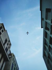 Low angle view of airplane flying against sky