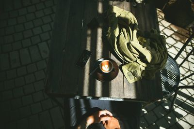 High angle view of man with coffee and smart phone sitting at table