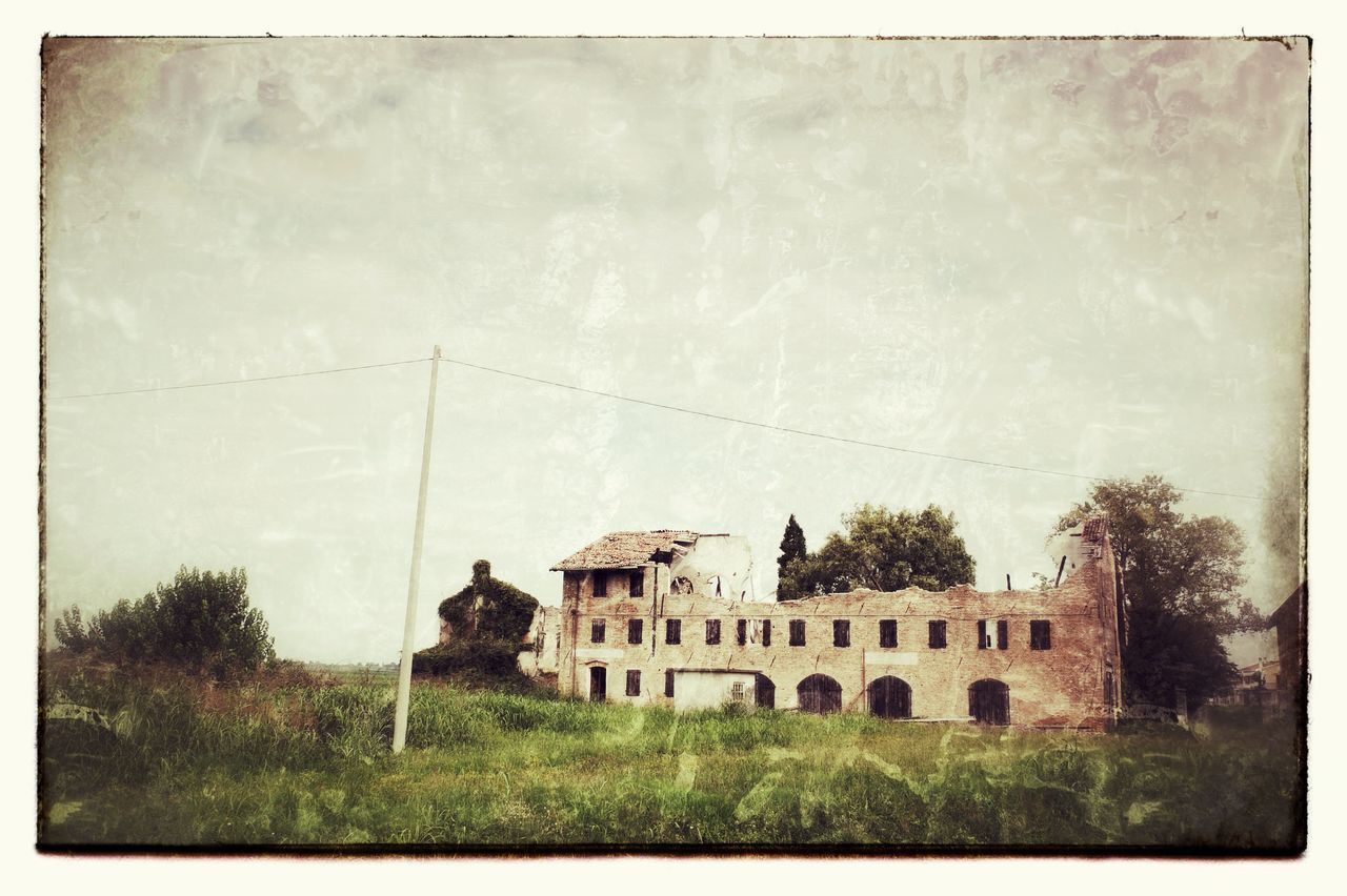 OLD BUILDING IN FIELD AGAINST SKY