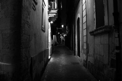 Alley amidst illuminated walkway