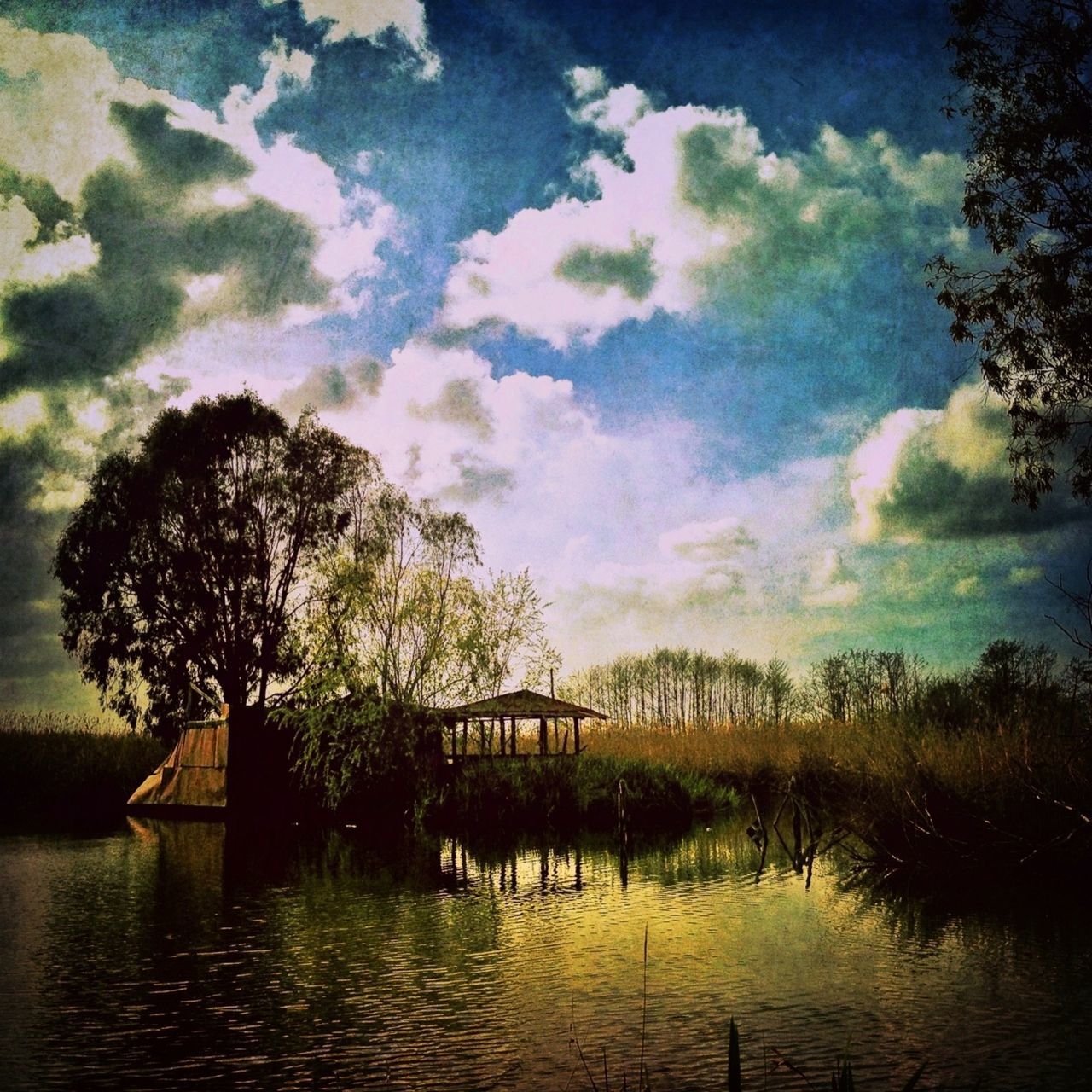 water, tree, sky, tranquility, lake, tranquil scene, waterfront, reflection, scenics, nature, cloud - sky, beauty in nature, river, cloud, idyllic, rippled, growth, built structure, no people, outdoors