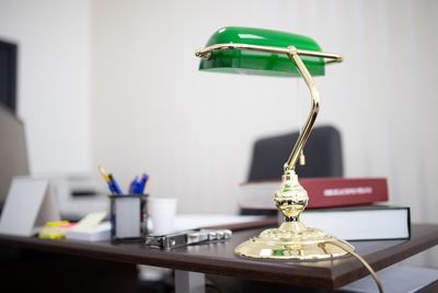 Close-up of electric lamp on table at office