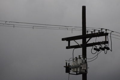 Low angle view of electricity pylon against clear sky