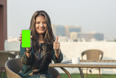 Portrait of young woman drinking glass