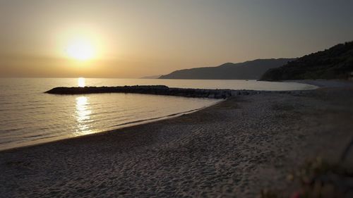 Scenic view of beach against sky during sunset