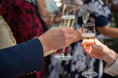 Cropped hands of friends toasting champagne flutes in party