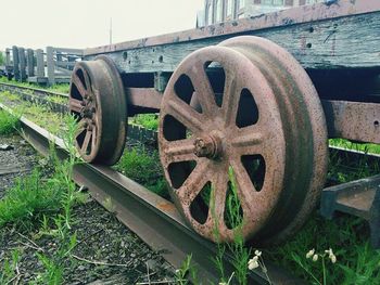 Close-up of rusty wheel on field