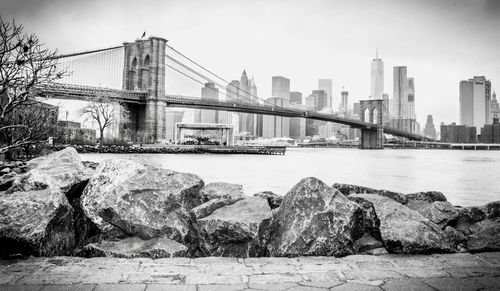 Low angle view of brooklyn bridge over east river at manhattan