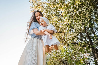 Young woman standing against trees