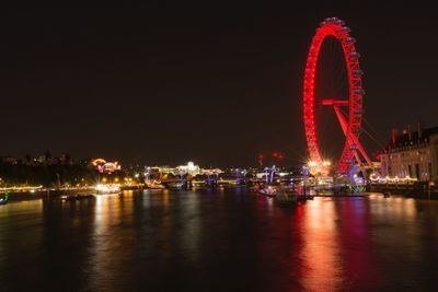 Illuminated ferris wheel in city at night