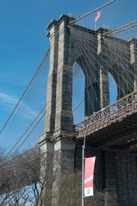 Low angle view of suspension bridge against sky