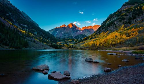 Scenic view of lake by mountains against sky