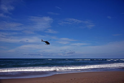 Helicopter flying over beach