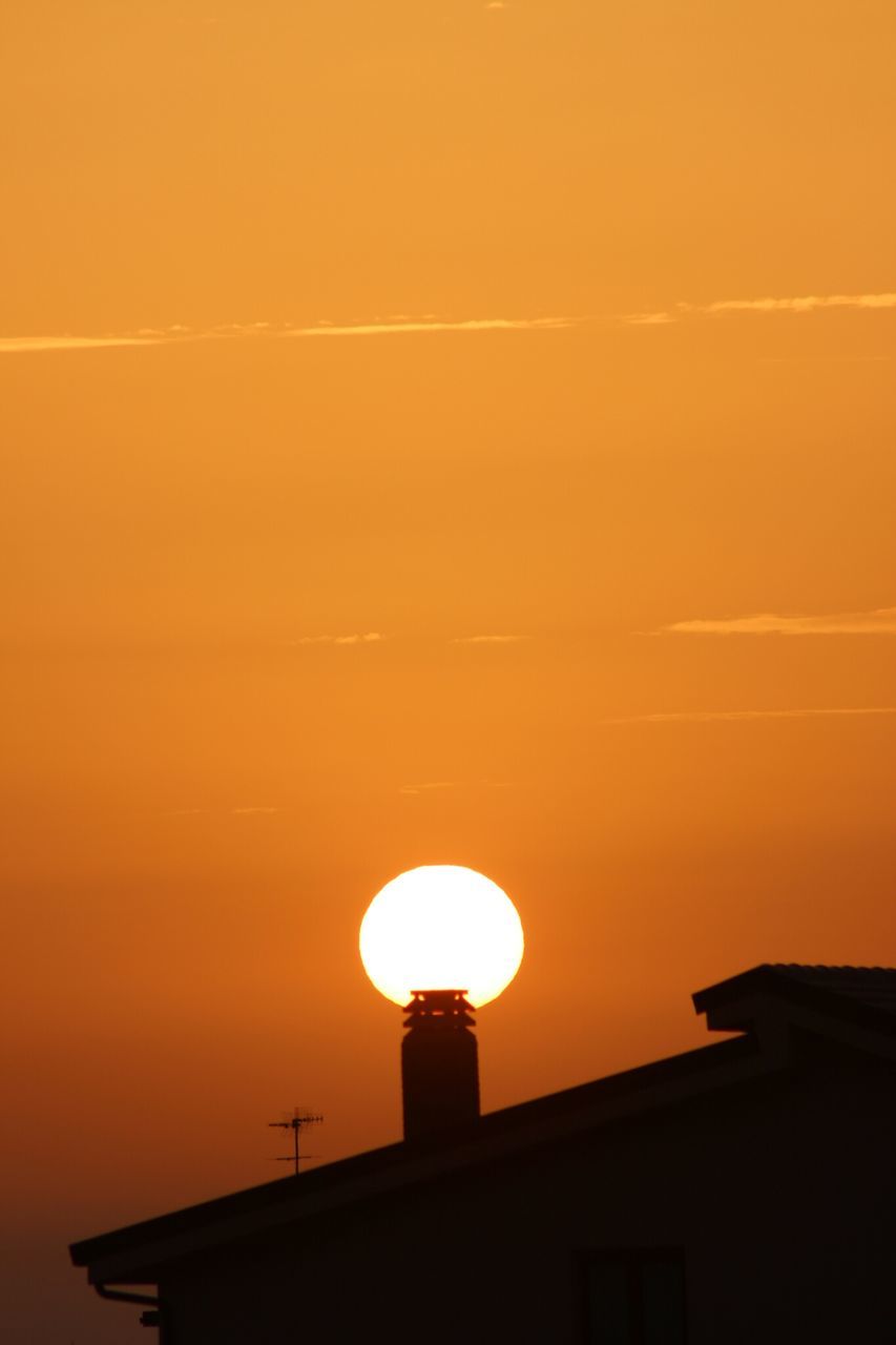 sunset, orange color, built structure, architecture, low angle view, building exterior, silhouette, sky, high section, sun, copy space, house, building, lighting equipment, no people, outdoors, residential structure, street light, nature, scenics