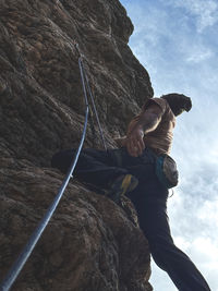 Low angle view of man climbing on mountain