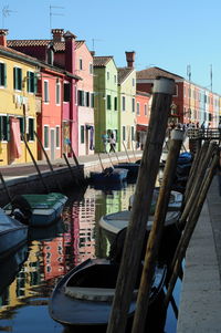 Boats moored in canal amidst buildings in city