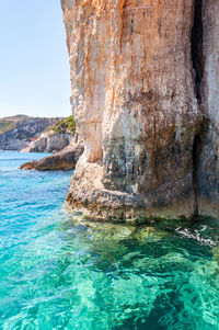 Rock formation in sea against sky