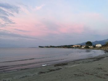 Scenic view of beach against sky at sunset