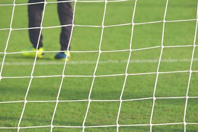 Low section o f man standing on soccer field