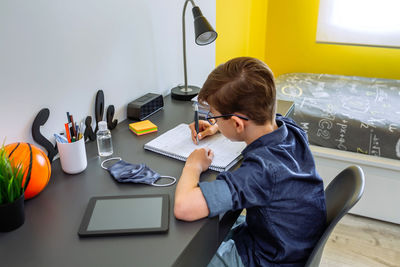 Man using laptop while sitting on table